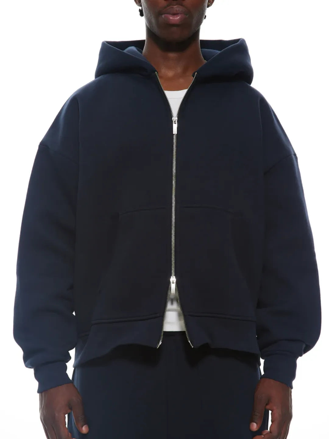Person wearing a navy blue zip-up jacket on a white background