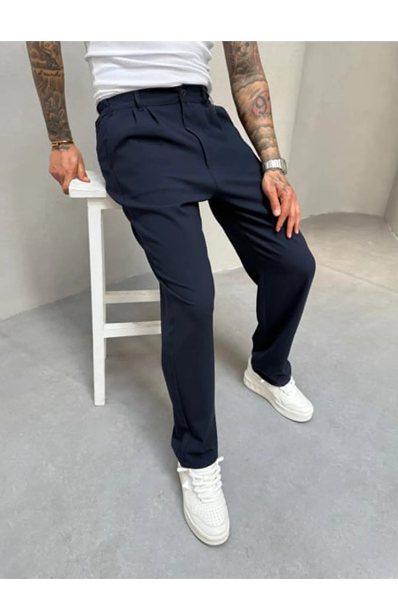 Person wearing navy blue pleated office pants 