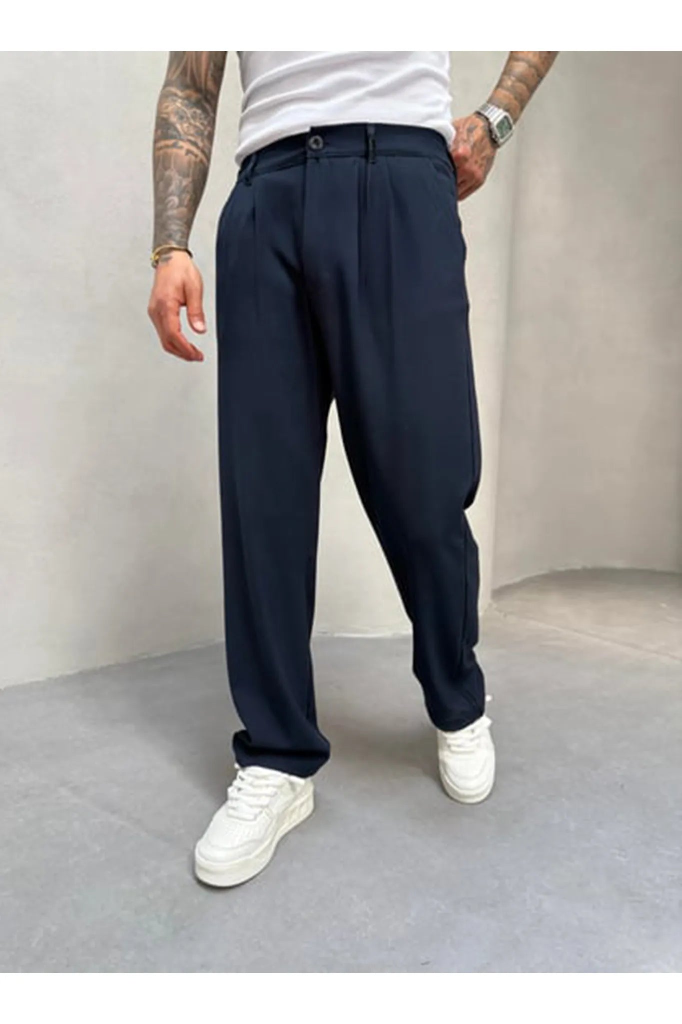 Person wearing navy blue pleated office pants 