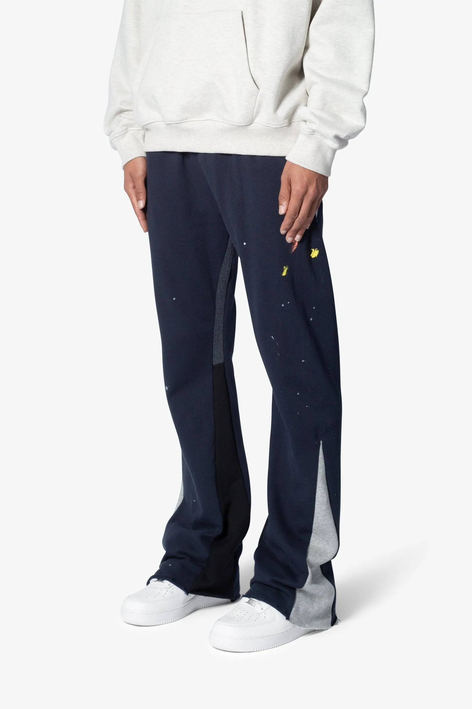Person wearing navy sweatpants with white accents on a white background