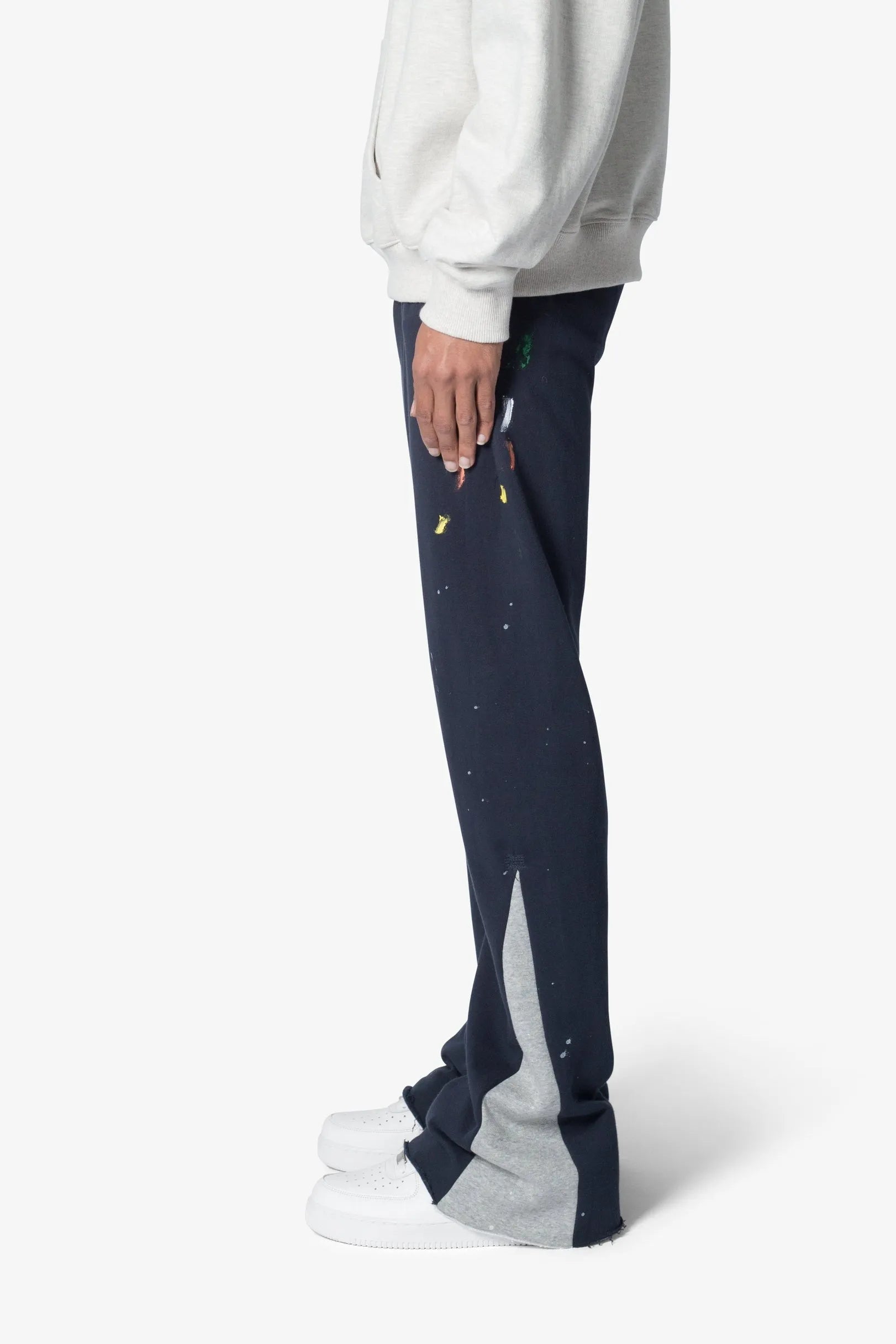 Navy blue pants with white accents worn by a person on a white background