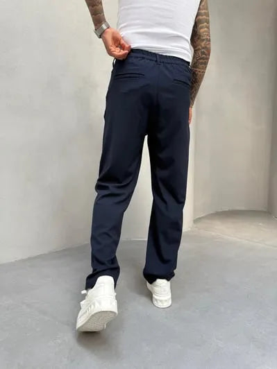 Person wearing navy blue pleated office pants 