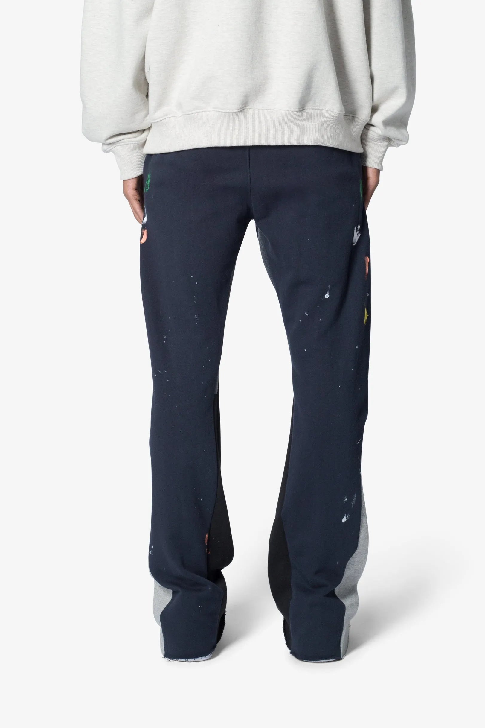 Person wearing navy pants with colorful accents on a white background