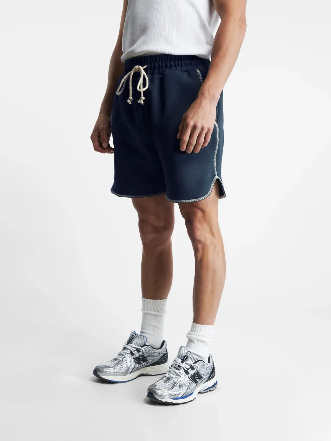 Person wearing navy running shorts with a white background