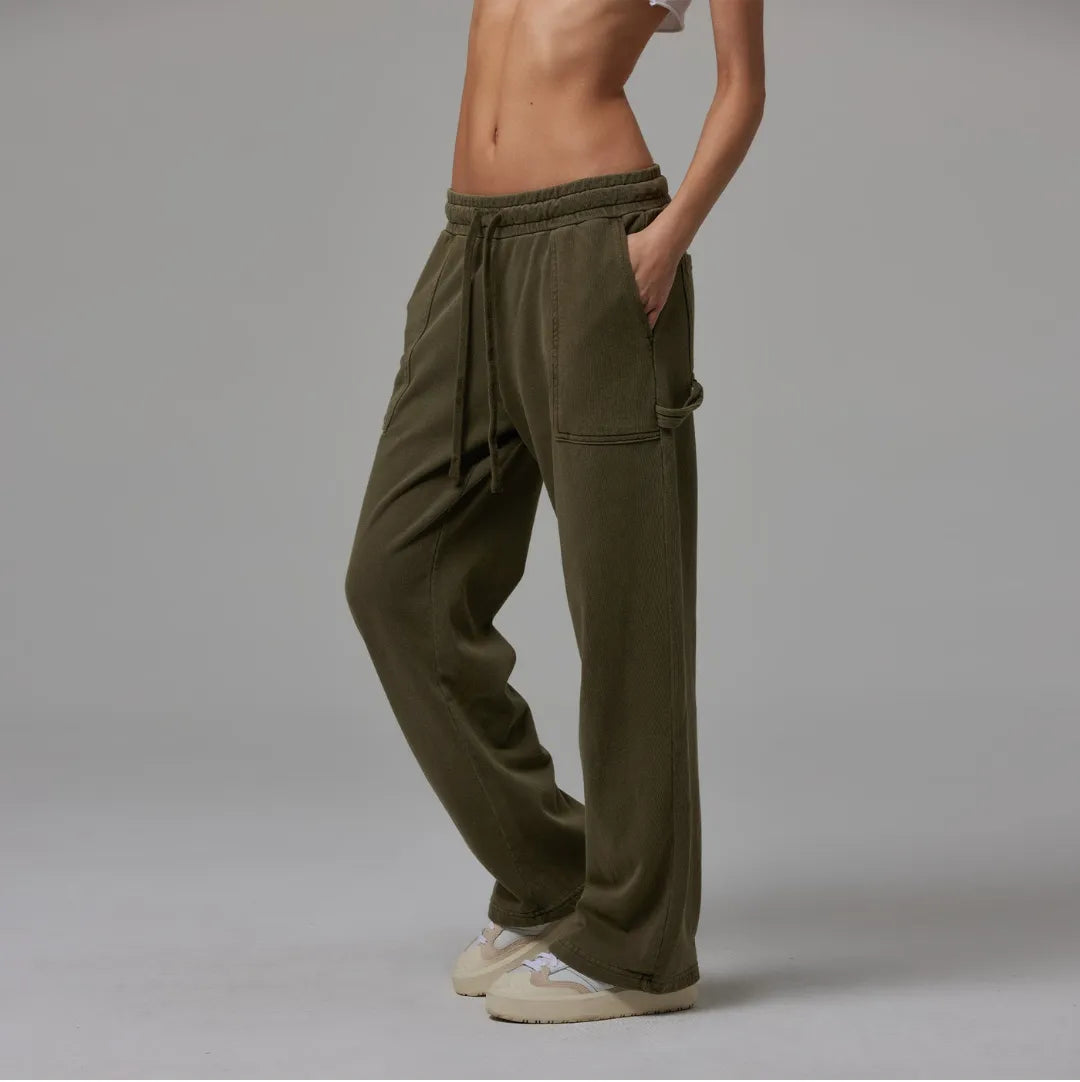 Person wearing olive drawstring sweatpant on a plain background