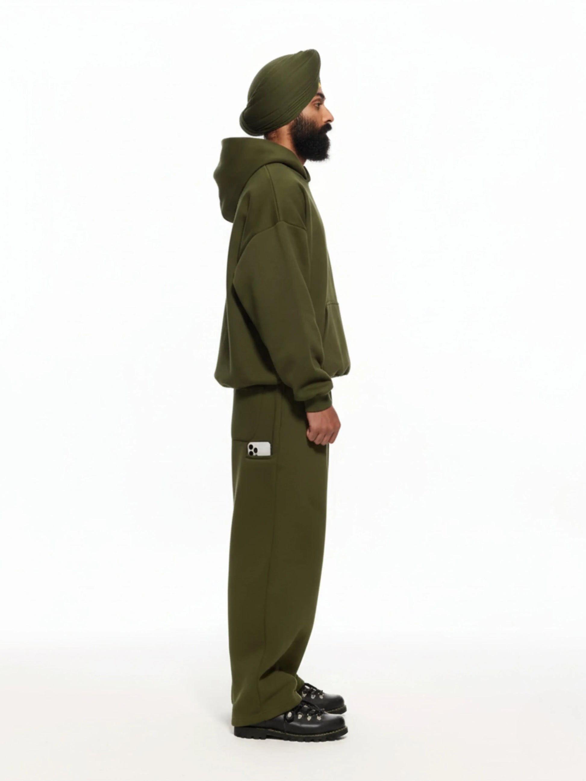 Person wearing a green tracksuit and turban on a white background