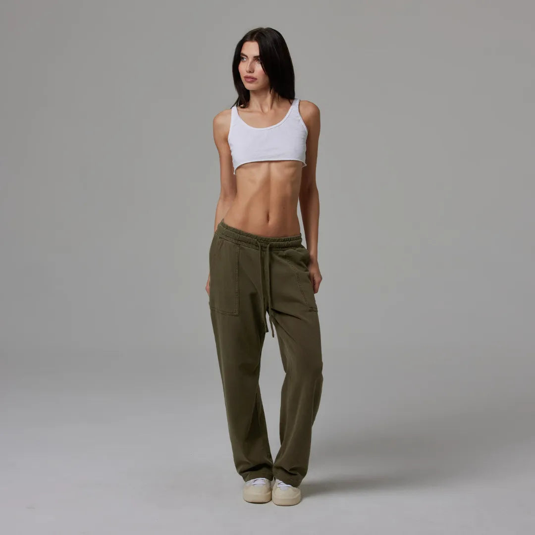 Person wearing olive drawstring sweatpant on a plain background
