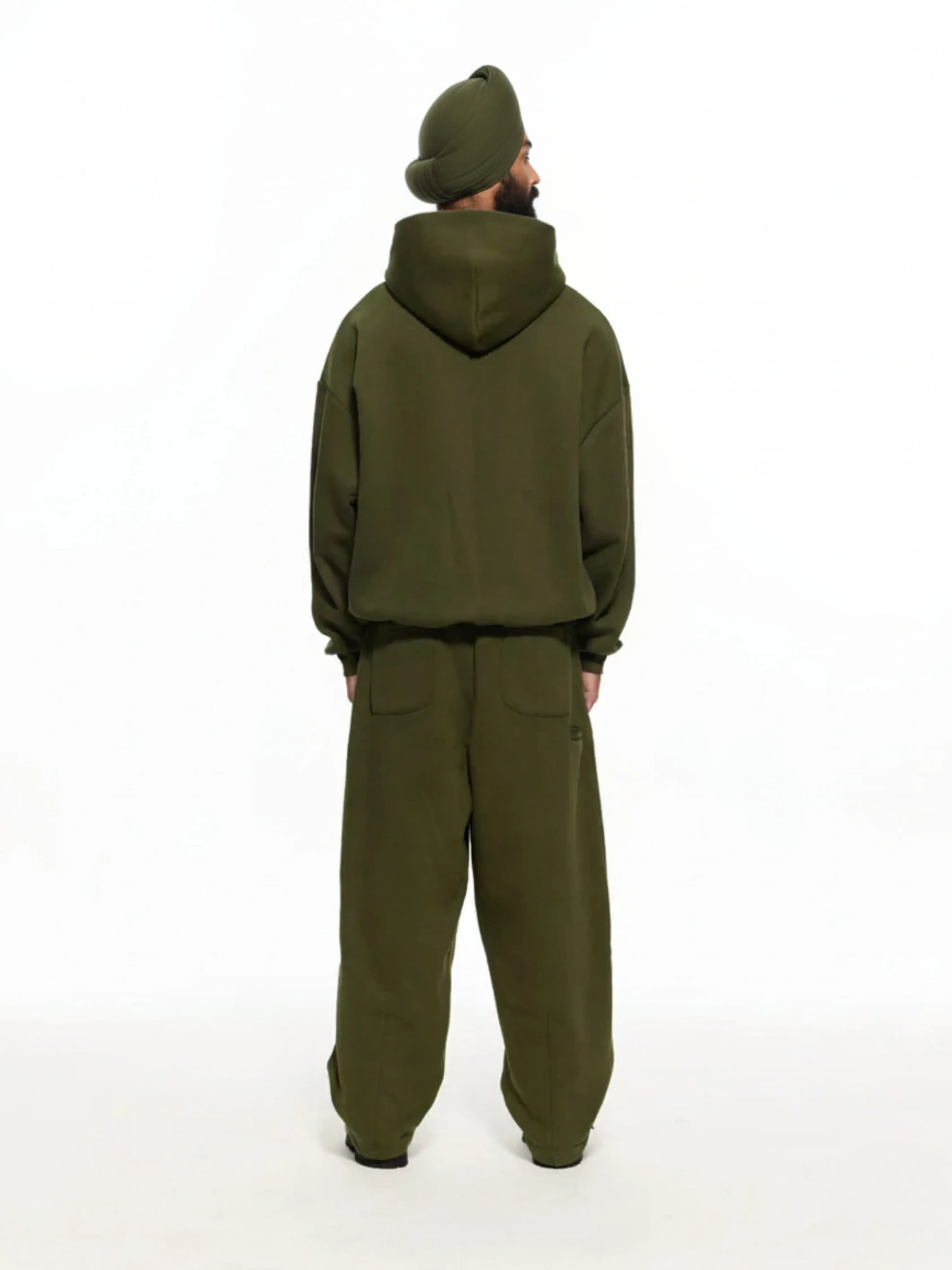 Person wearing a green tracksuit on a white background