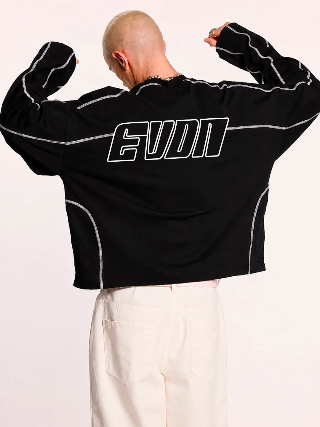 Person wearing a black long-sleeve t-shirt with white accents and EVDN logo