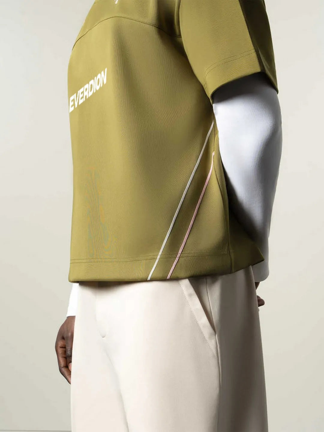 Person wearing a green jacket with 'EVERNOM' branding on a plain background