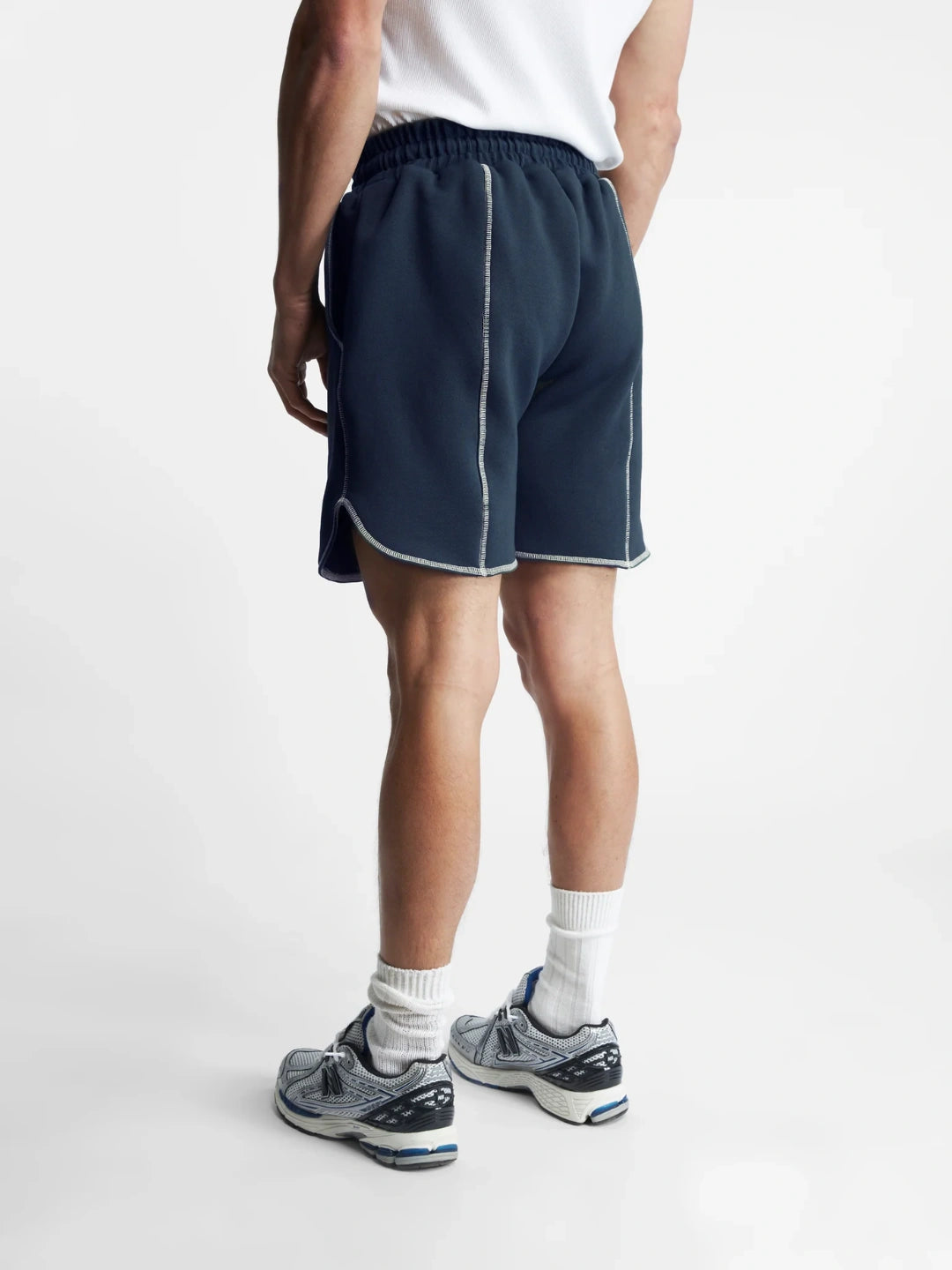 Person wearing navy shorts on a white background