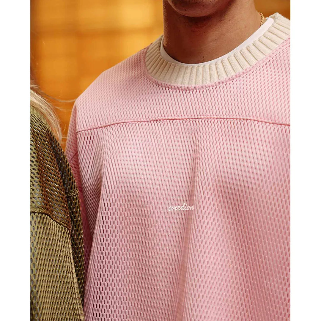 Close-up of a pink textured sweater with a blurred background