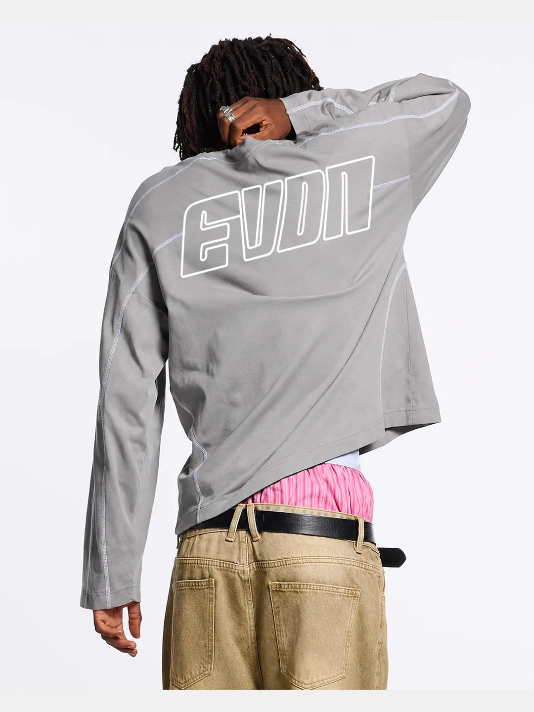 Person wearing a grey long-sleeve t-shirt with white accents and EVDN branding