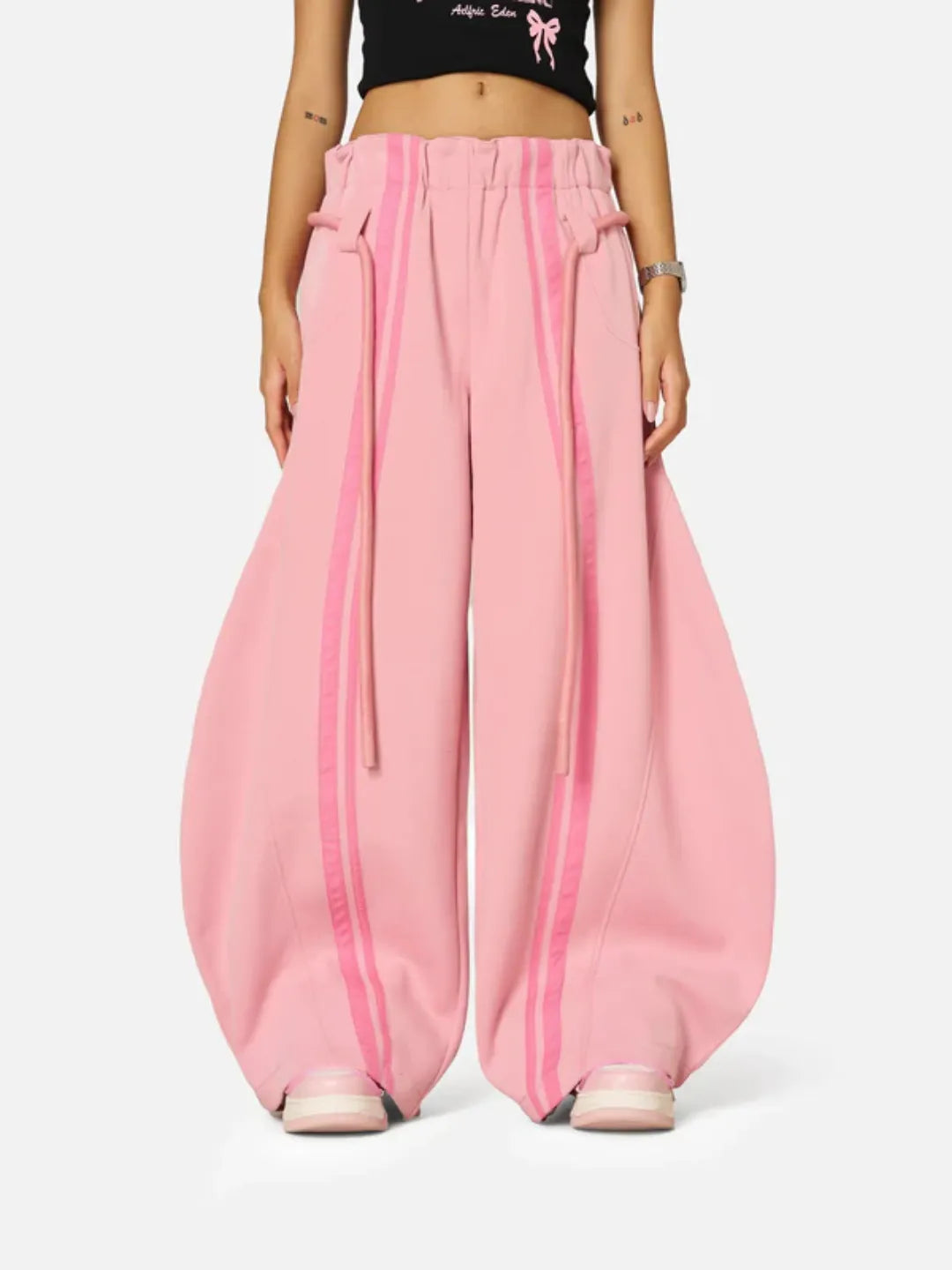 Person wearing pink wide-leg sweatpants with a white background