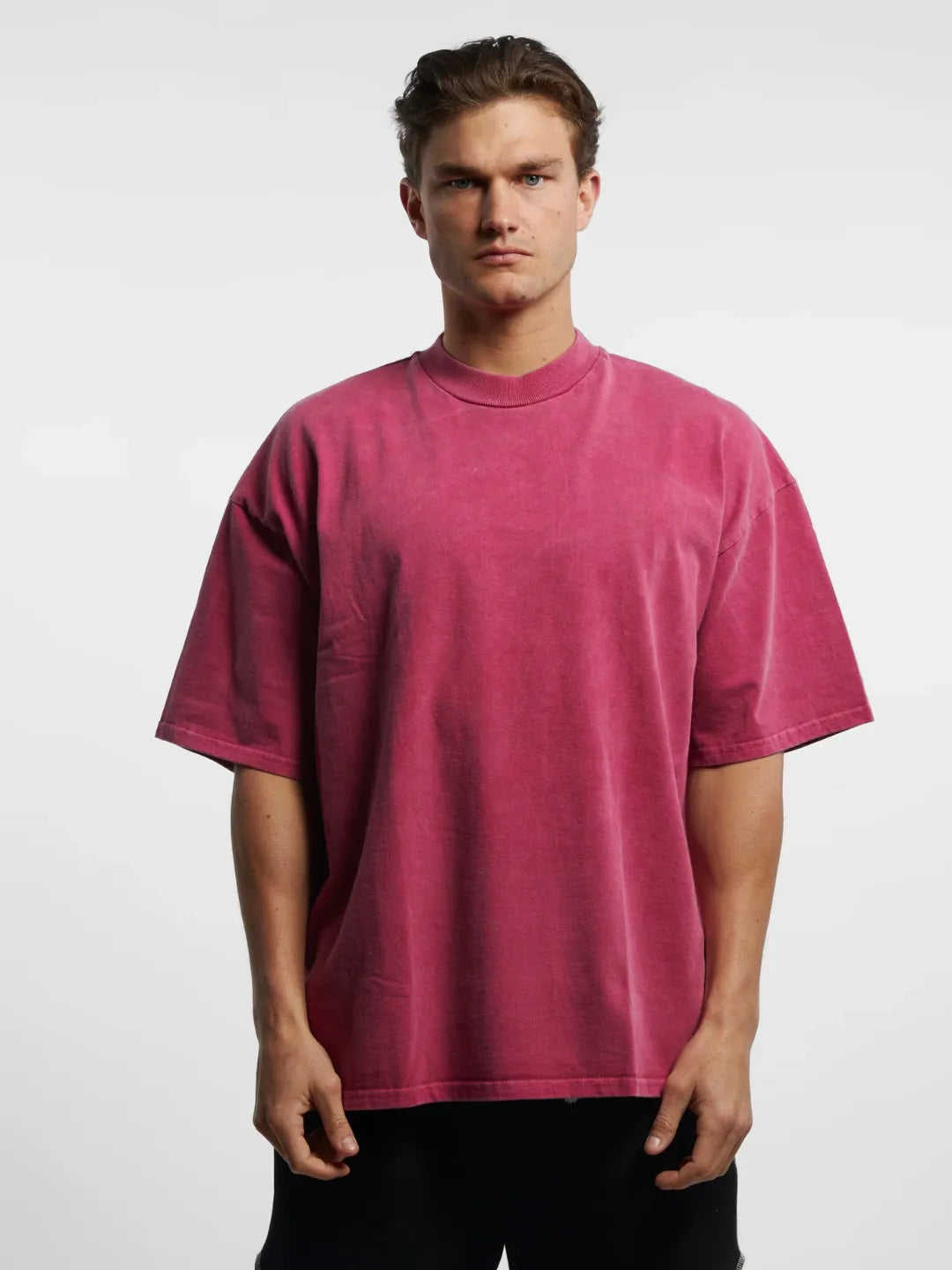 Man wearing a pink t-shirt against a white background