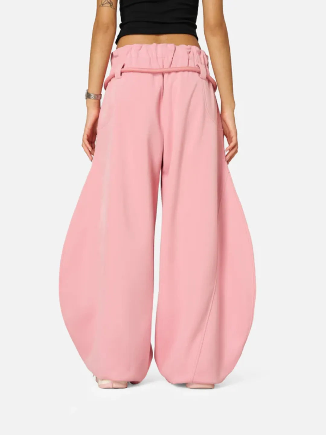 Person wearing pink wide-leg sweatpants on a white background