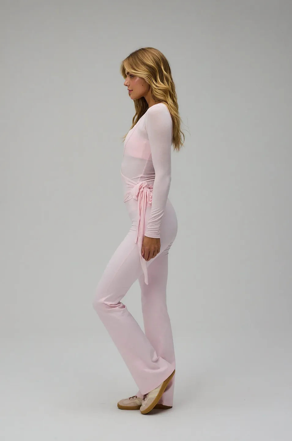 Woman wearing a pink outfit on a plain background
