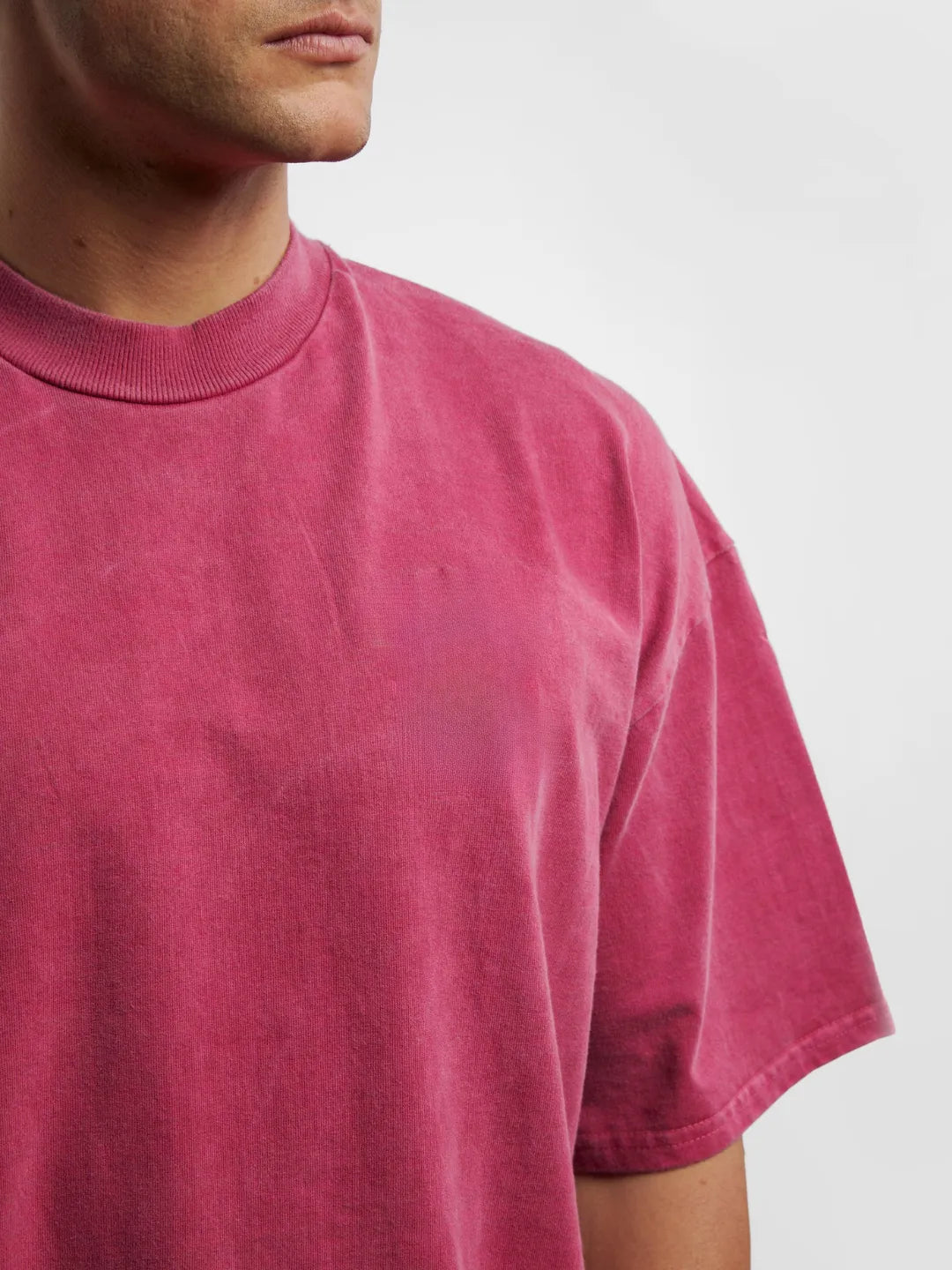 Person wearing a pink t-shirt against a white background