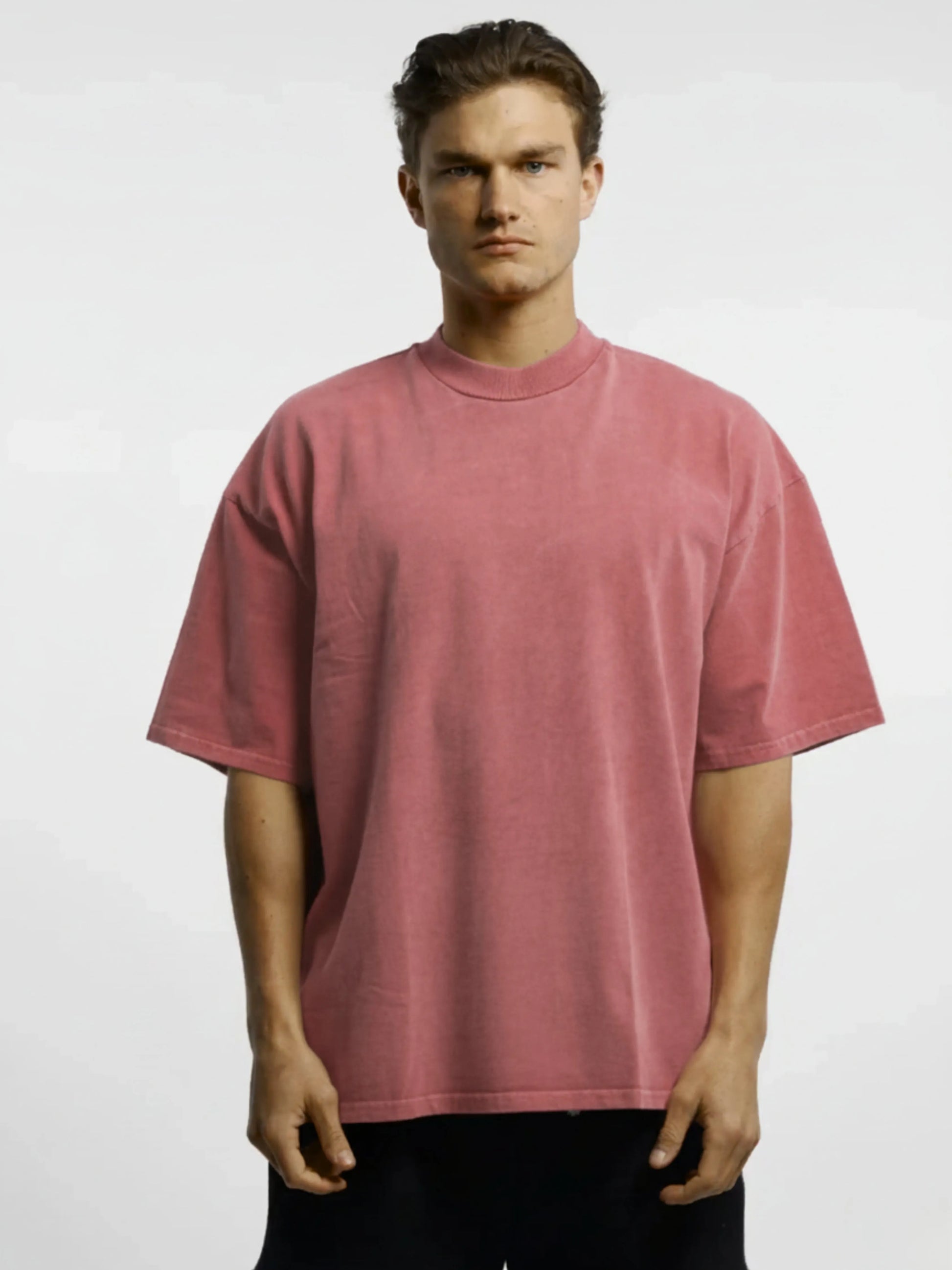 Man wearing a pink t-shirt against a white background