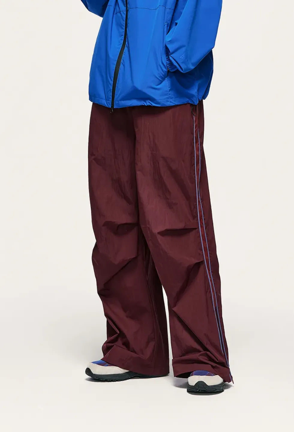 Person wearing a blue jacket and maroon pants on a white background