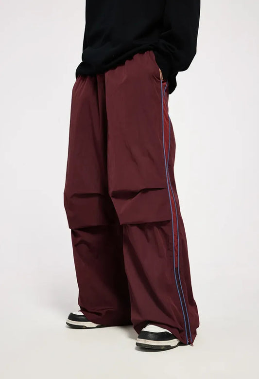 Maroon pants with a stripe worn by a person on a white background