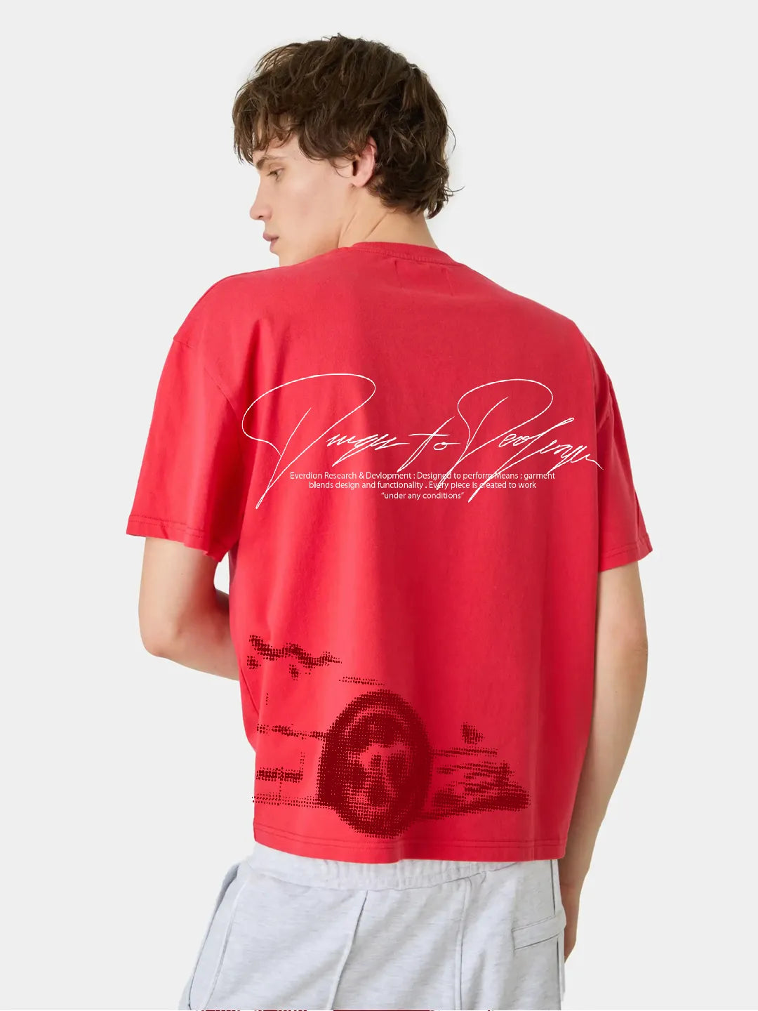 Person wearing a red t-shirt with text and graphics on the back, standing against a white background