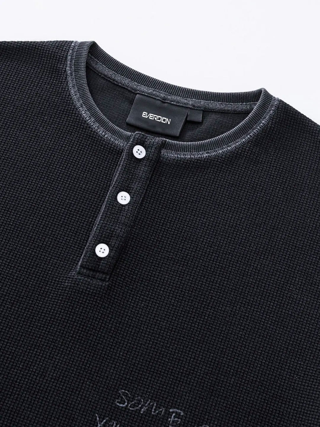Close-up of a black textured Henley shirt by Bercoon, featuring a three-button placket and a ribbed crew neck collar.