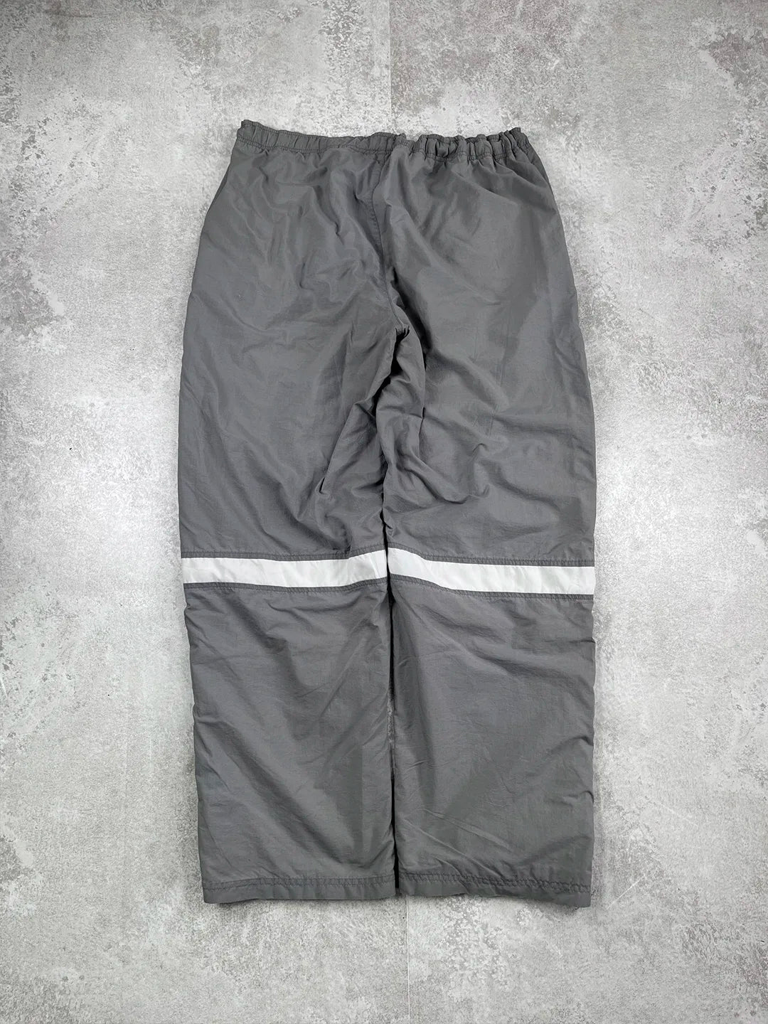 Grey reflective pants on a concrete floor