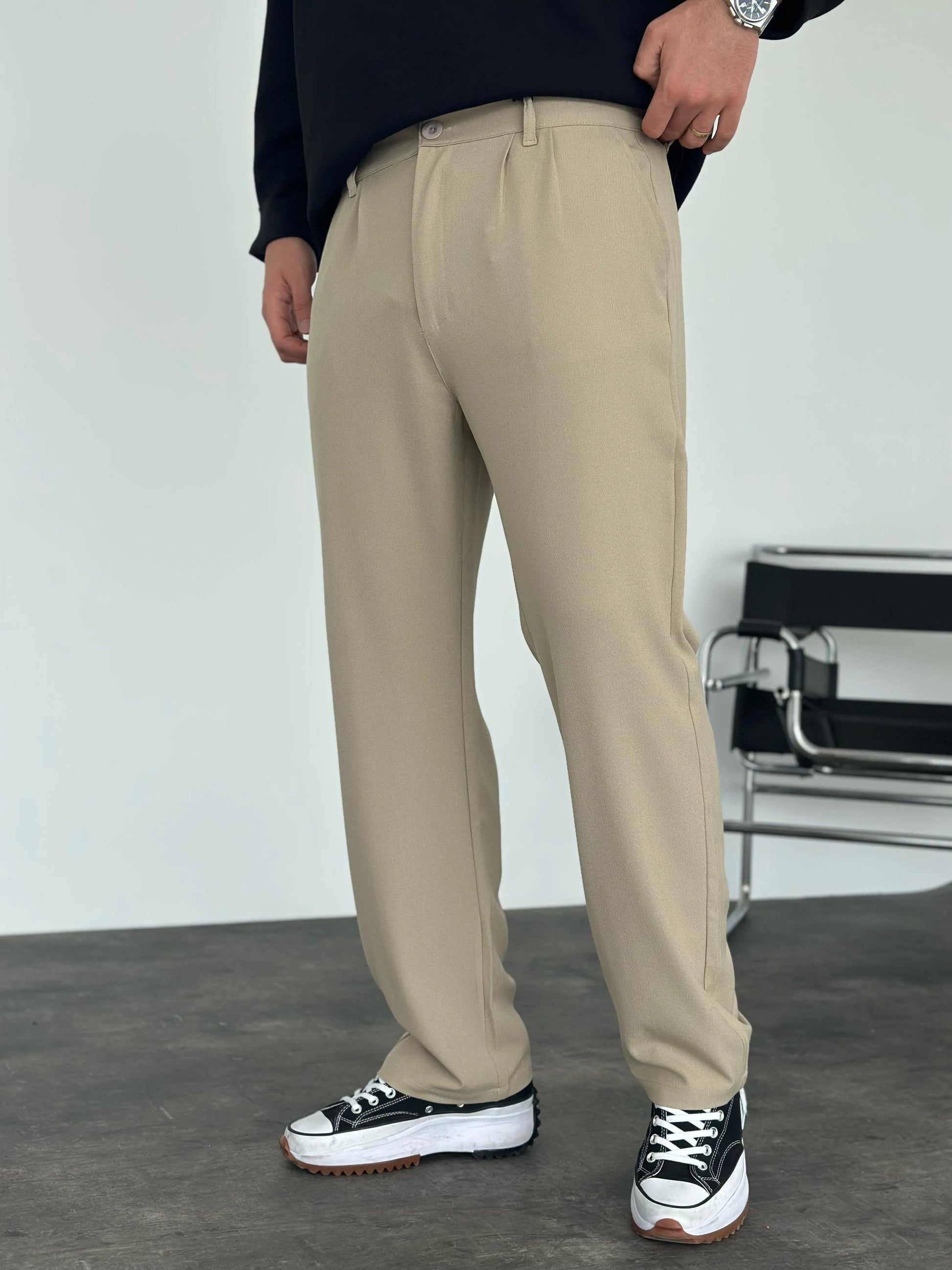Person wearing beige pleated office pants 