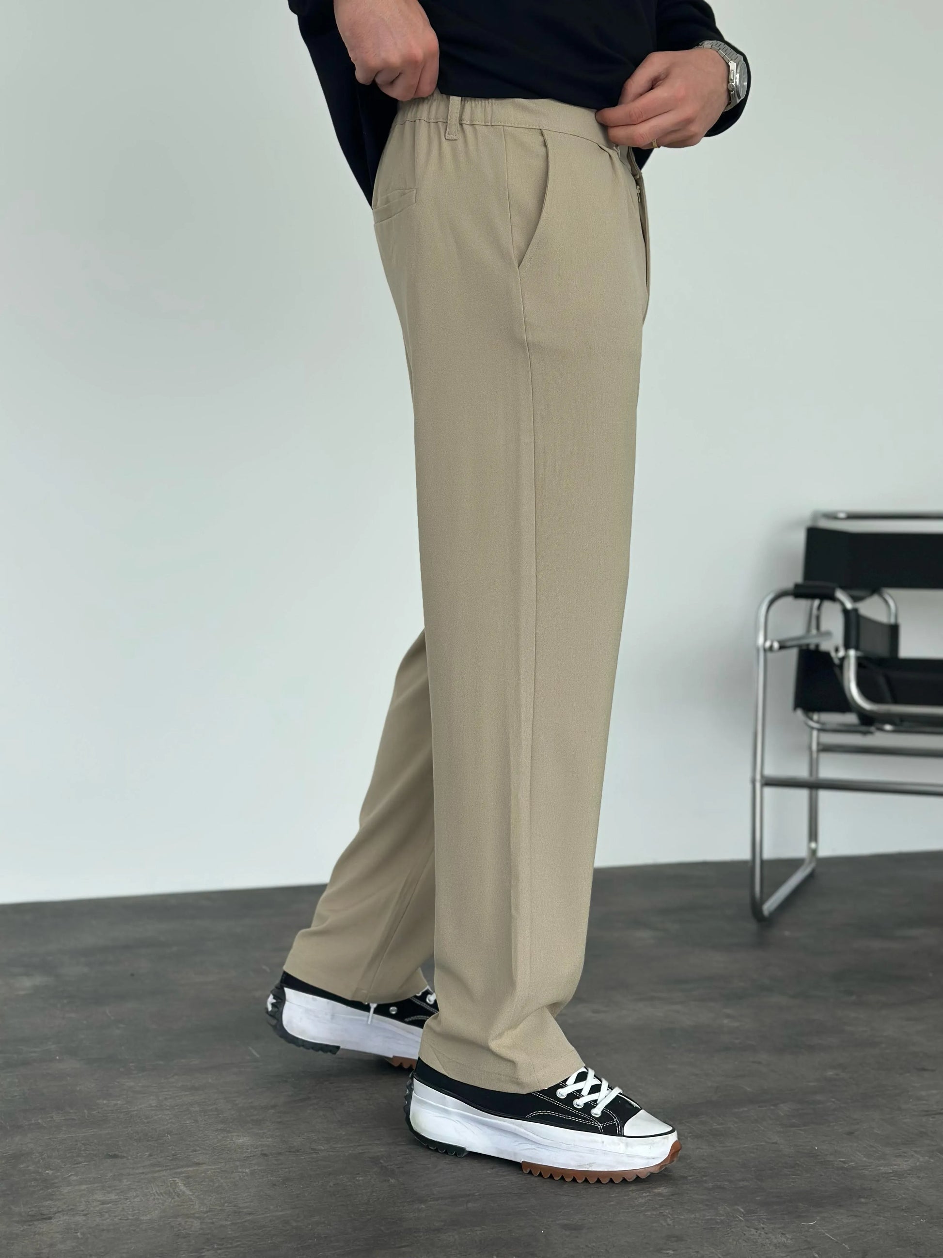 Person wearing beige pleated office pants 