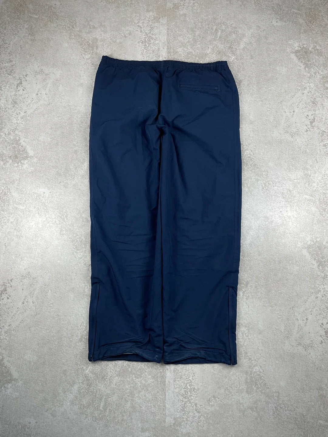Navy blue pants on a grey concrete floor