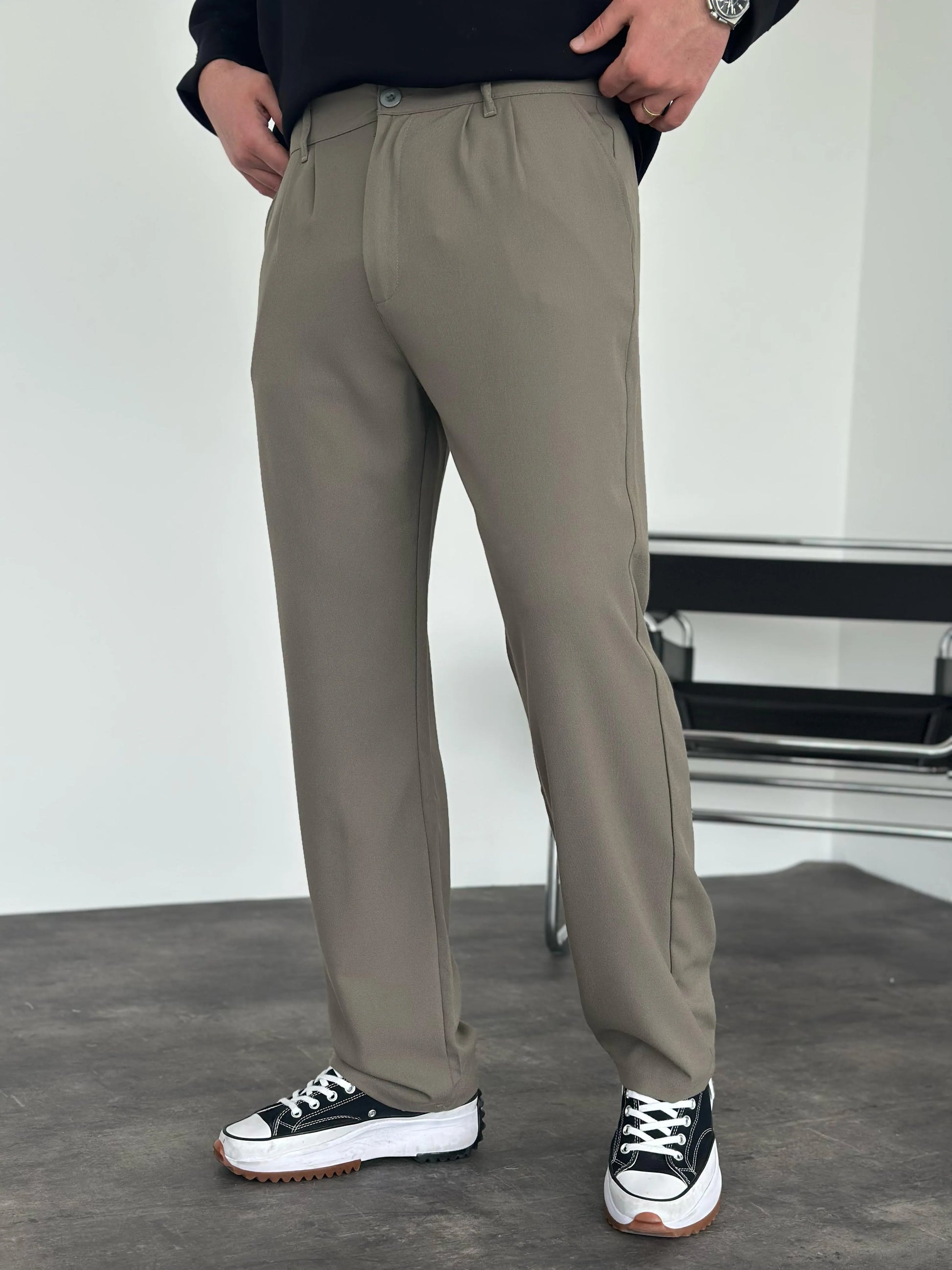 Person wearing grey pleated office pants 