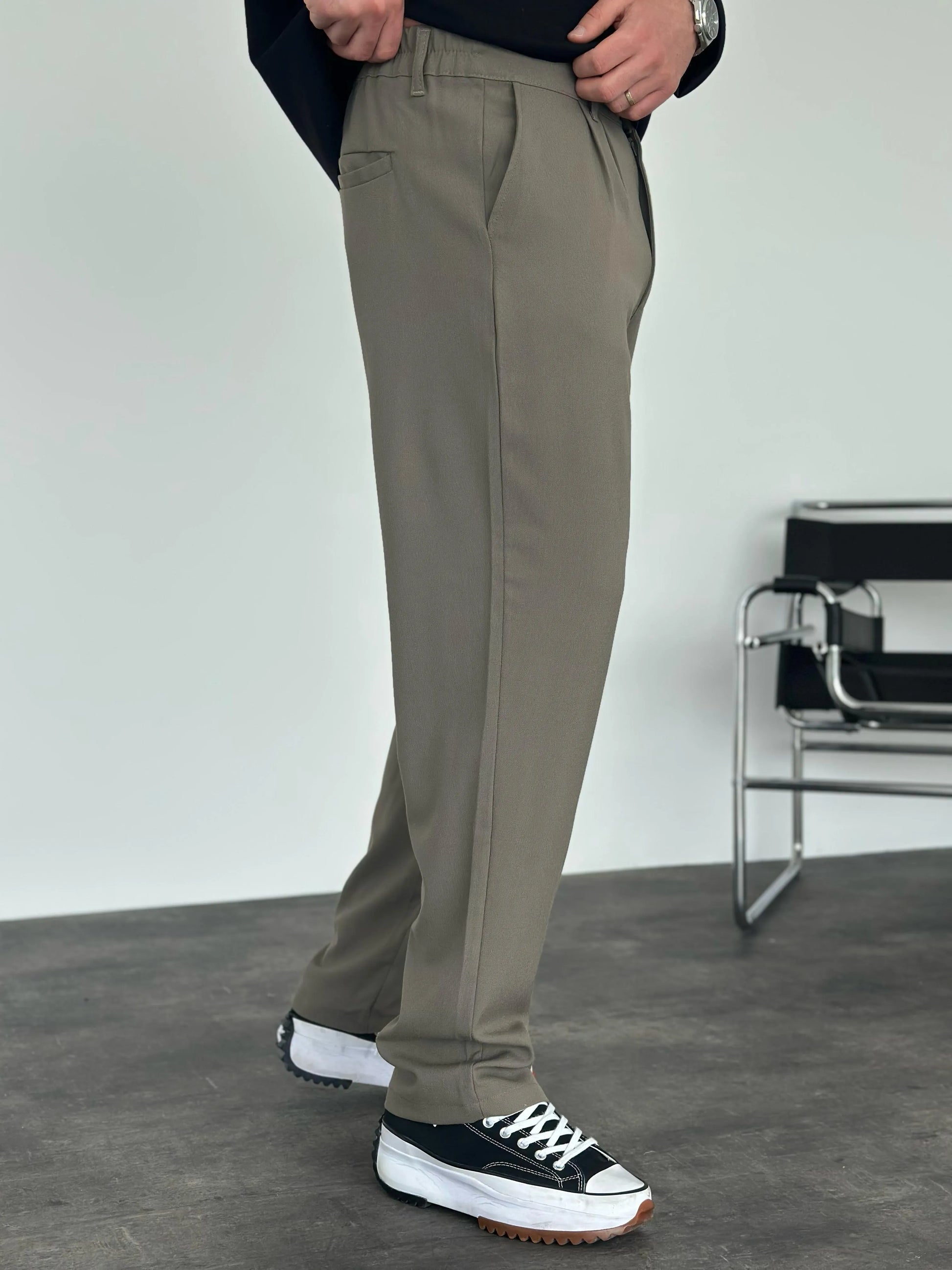 Person wearing grey pleated office pants 