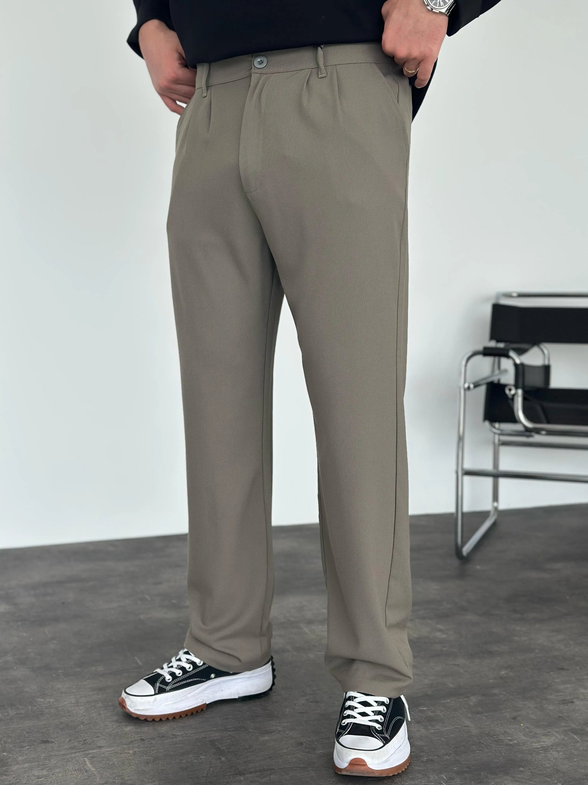 Person wearing grey pleated office pants 