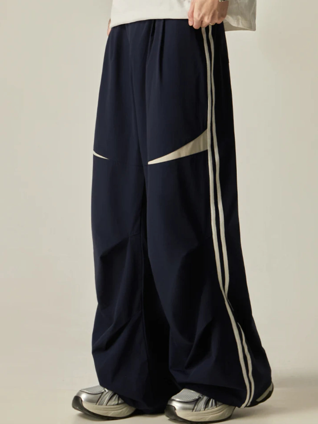 Navy wide-leg pants with white stripes on a beige background