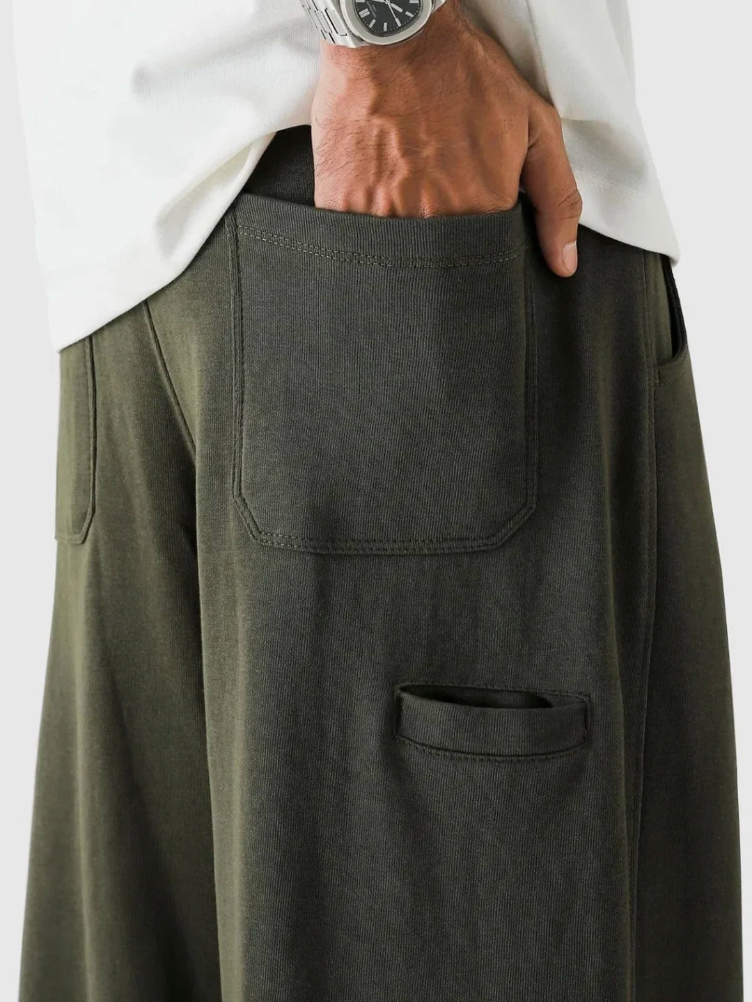 Person wearing a green skirt with two front pockets on a white background