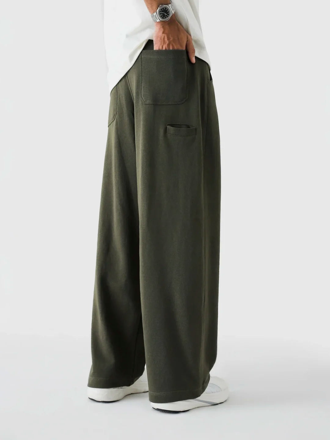 Person wearing olive green wide-leg pants on a white background