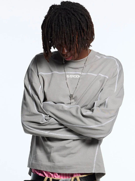 Person wearing a grey long-sleeve t-shirt with white accents 