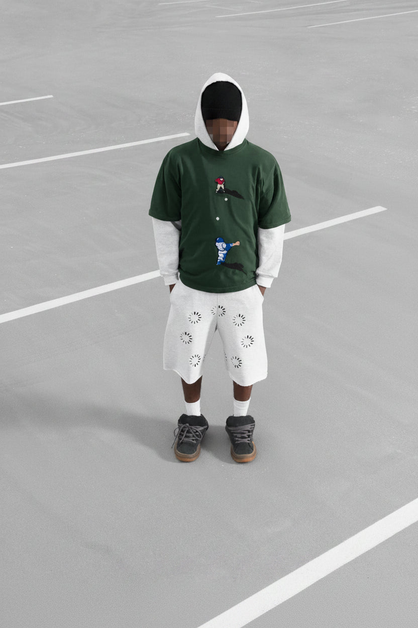 Person wearing a green hoodie with a graphic design on a grey surface