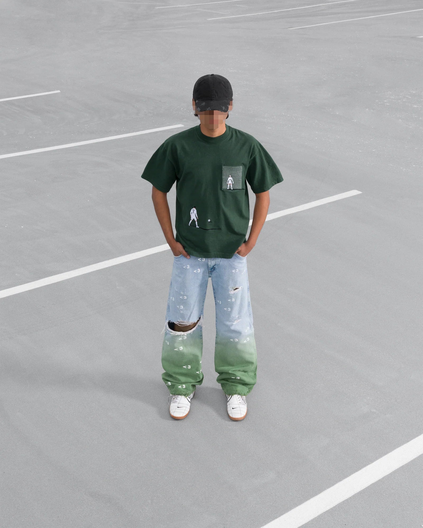 Person wearing a green t-shirt and gradient pants standing on a grey surface.