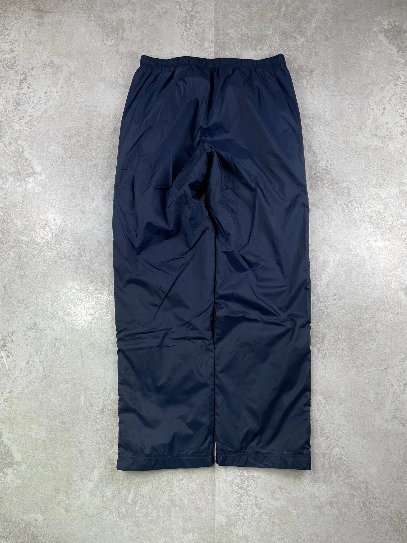 Navy blue pants on a grey concrete surface