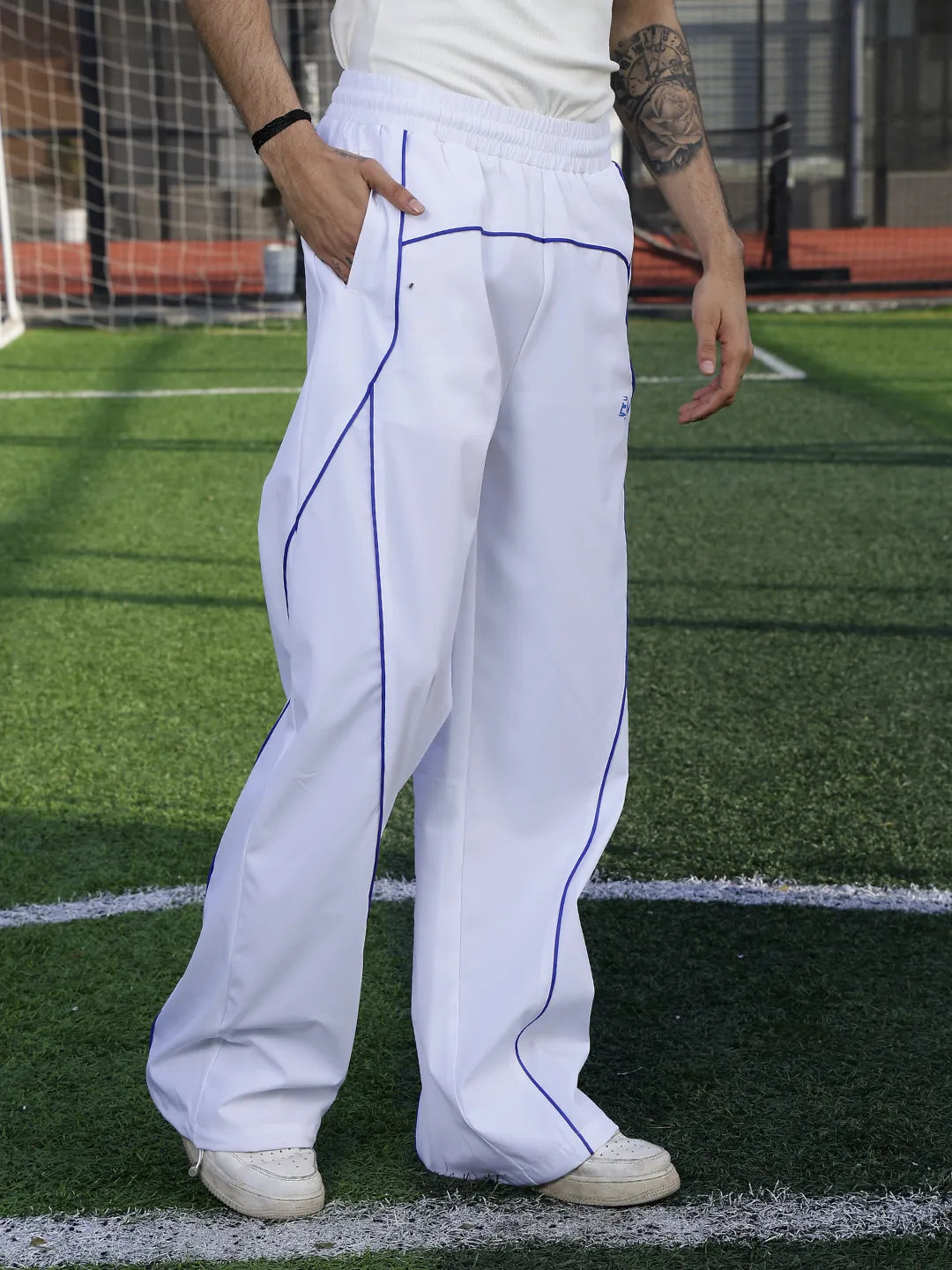 Person wearing white pants with a blue line on a sports field