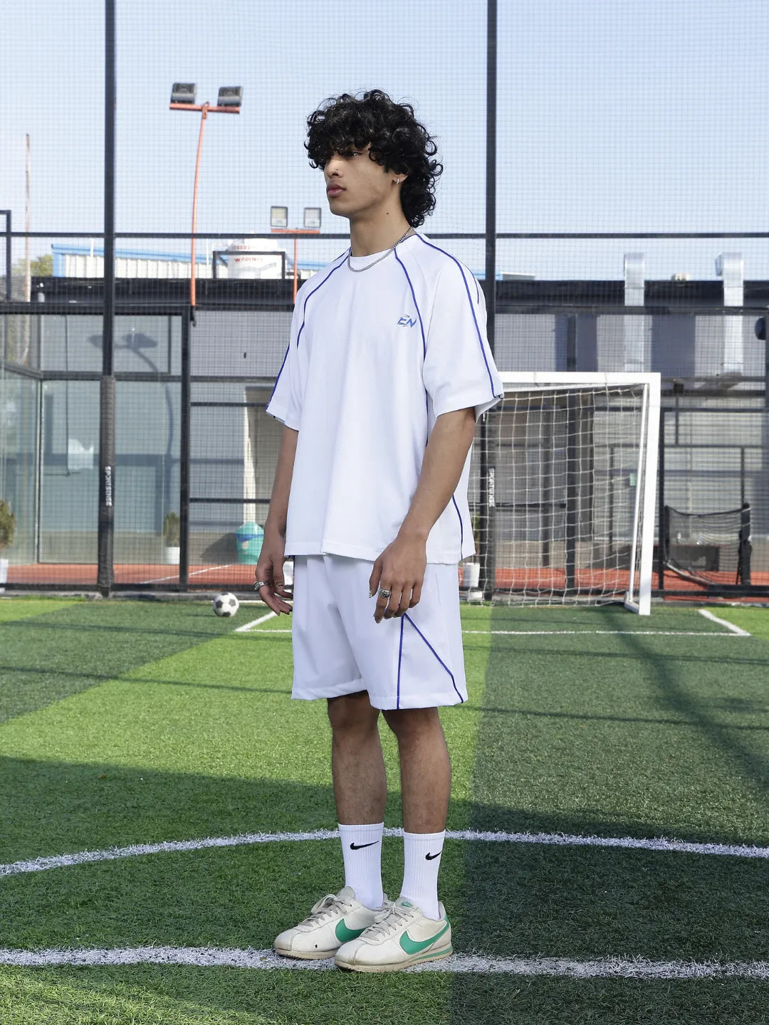 Person wearing a white sports outfit on a grassy field