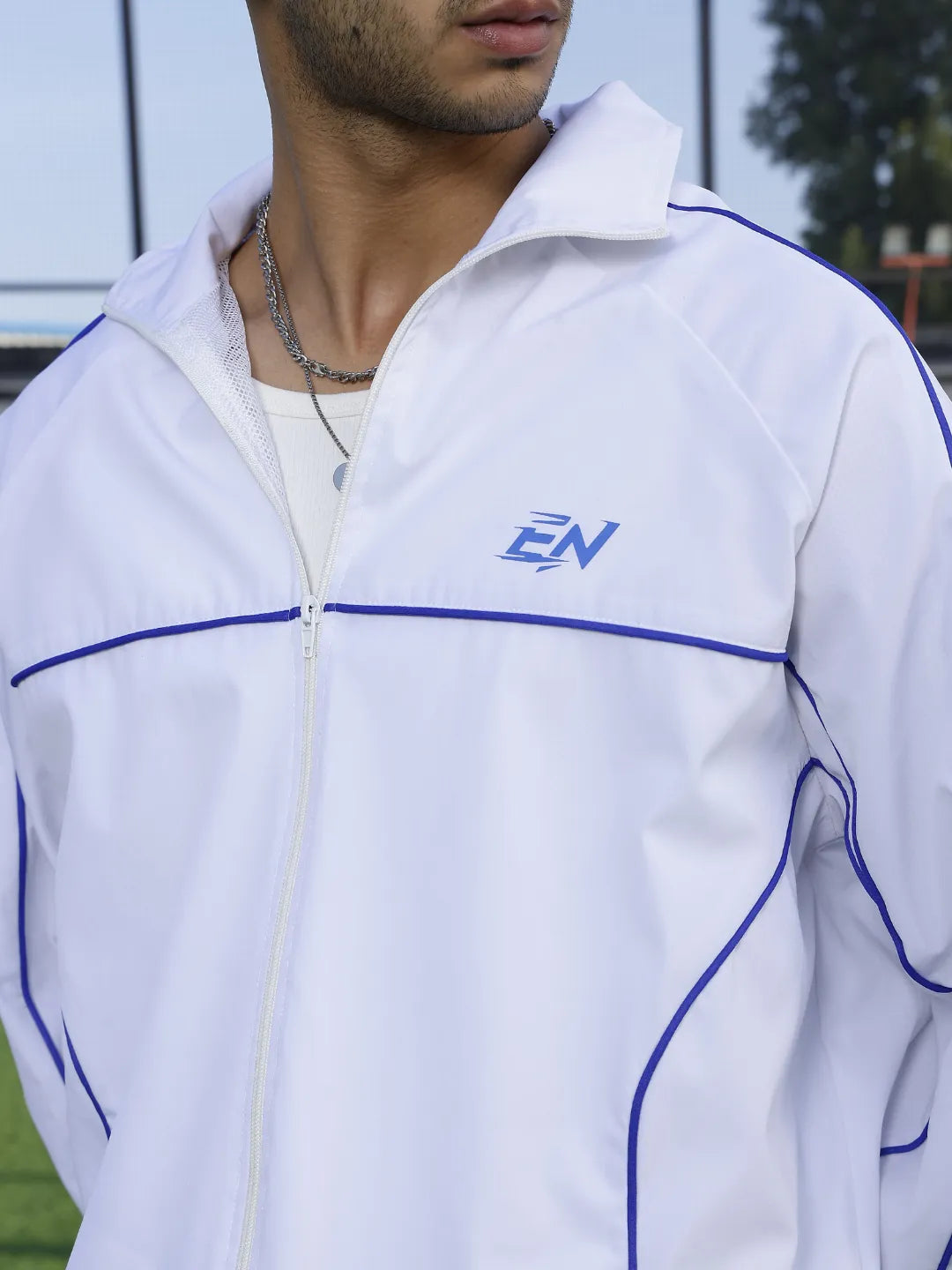 White jacket with blue accents and a logo on a person outdoors