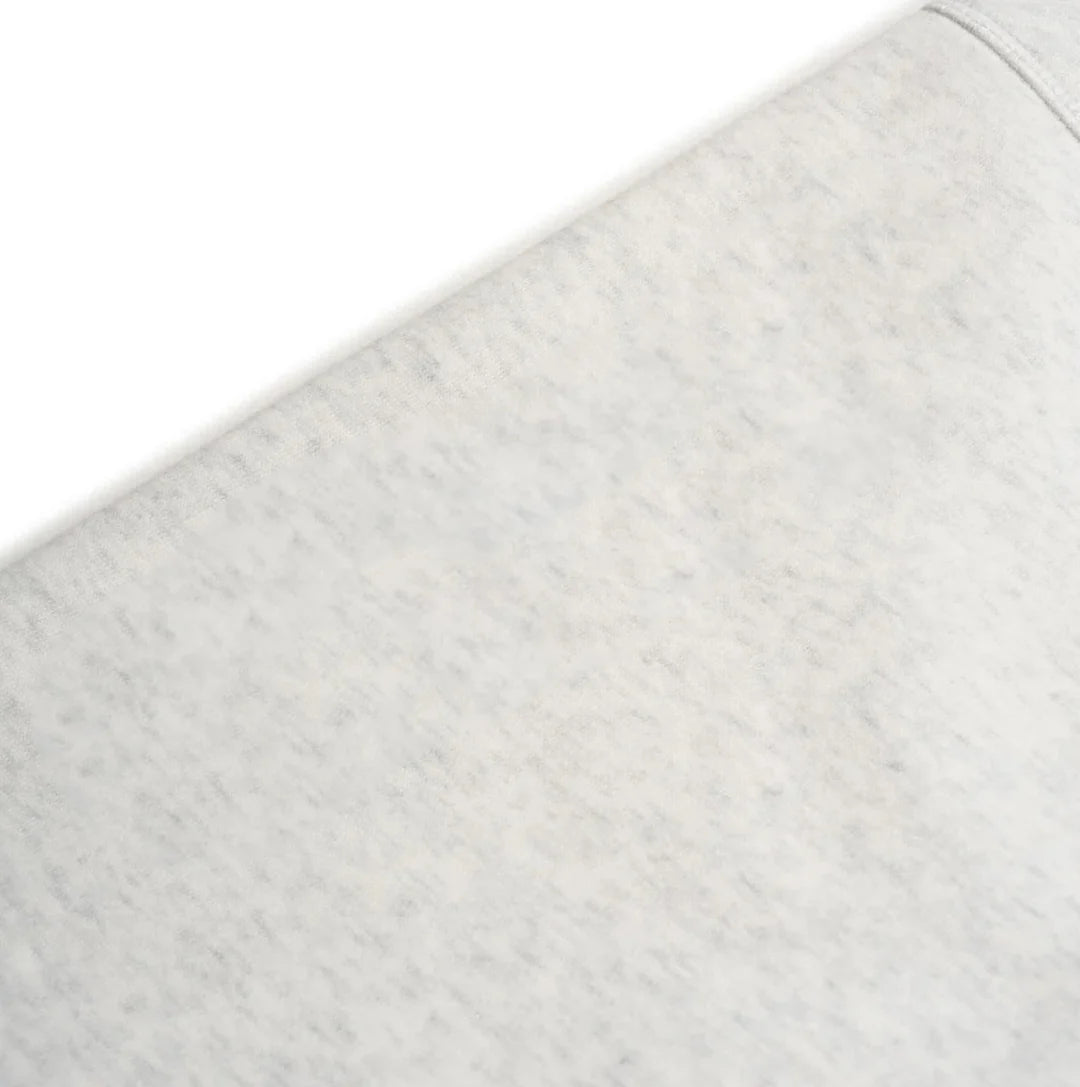 Close-up of a textured gray fabric with a subtle pattern on a white background