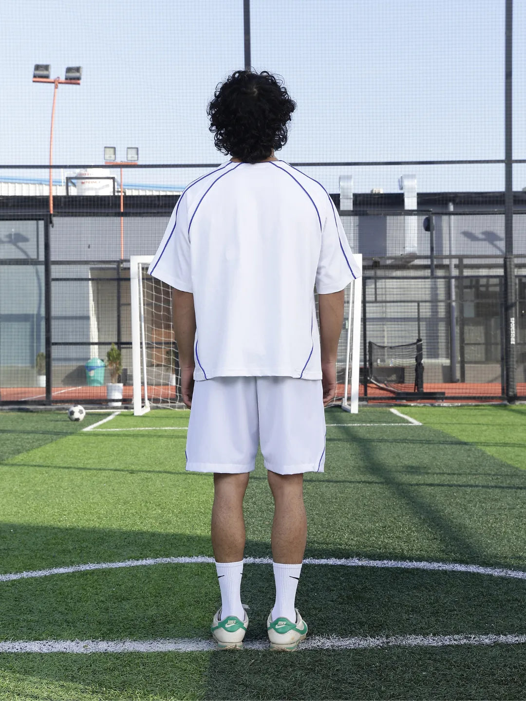Person wearing a white outfit on a sports field