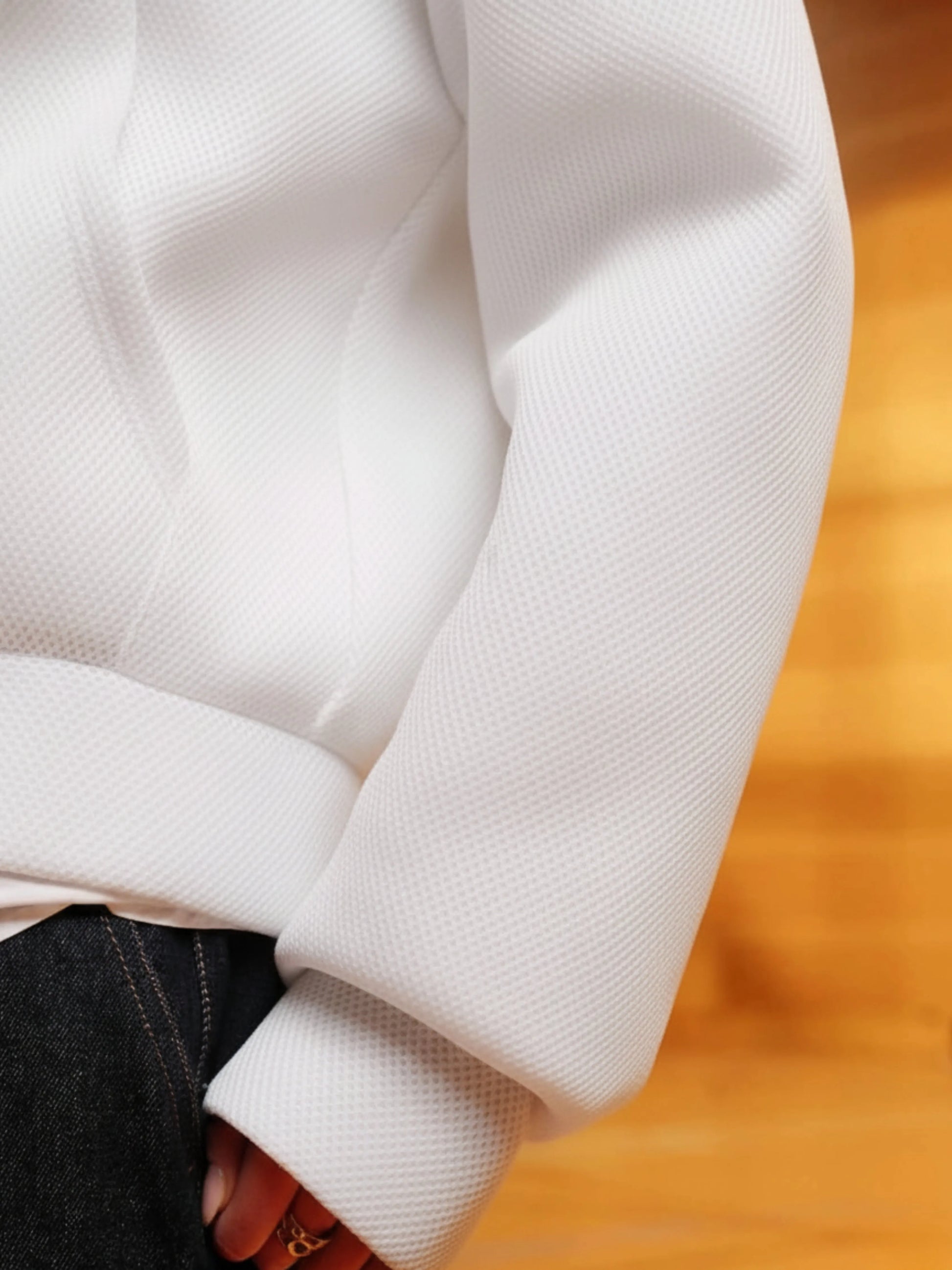 Close-up of a white hoodie sleeve on a wooden surface