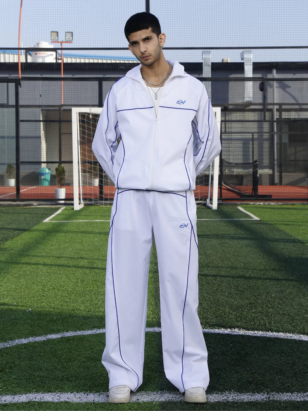 Person wearing a white tracksuit on a sports field