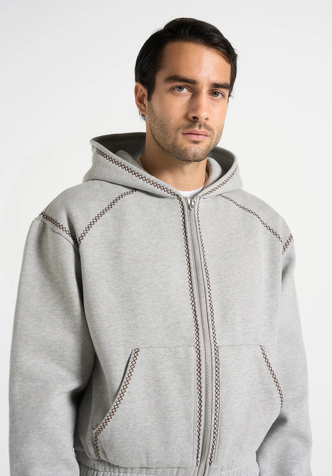 Man wearing a gray hoodie with a plain background