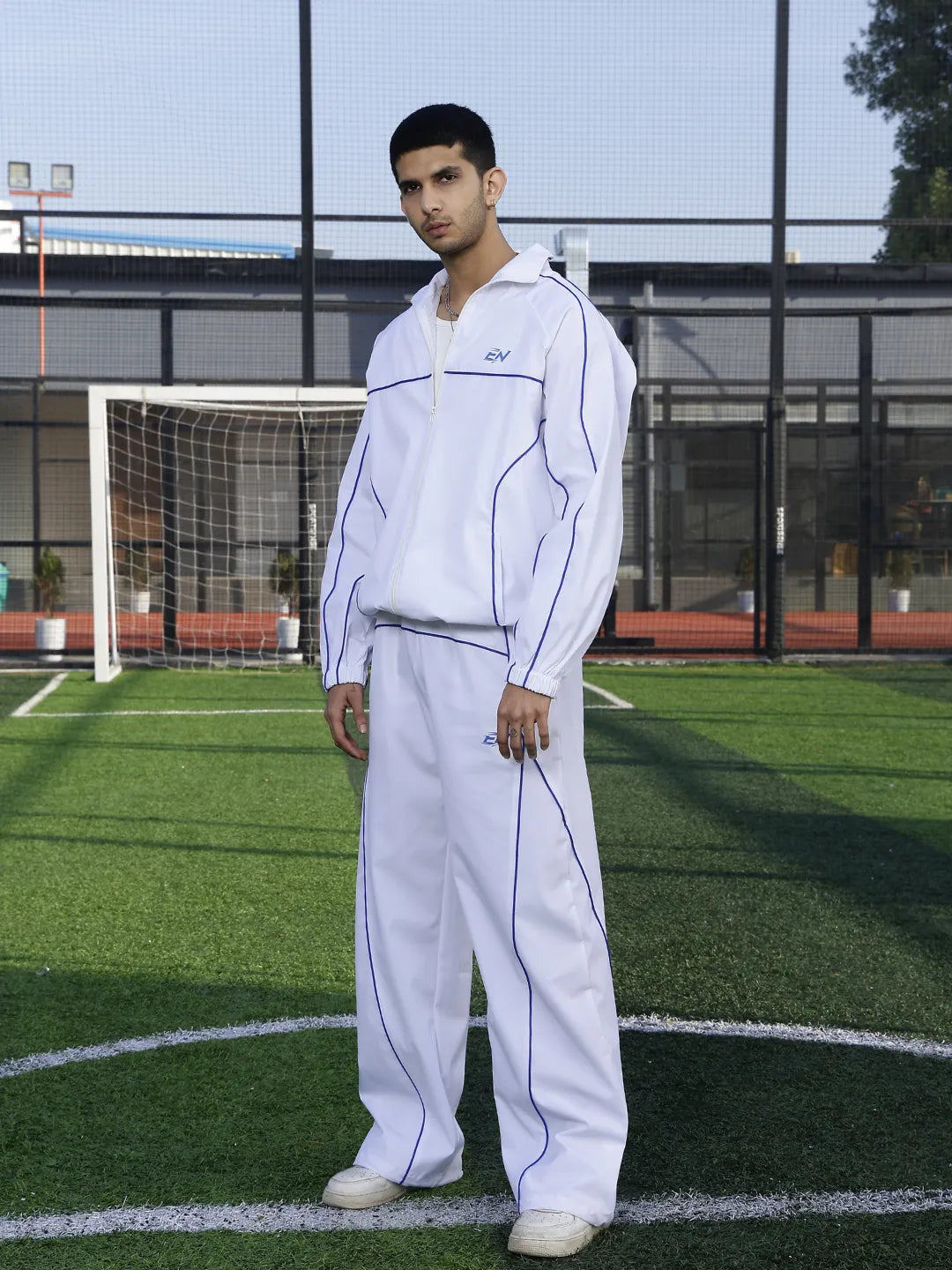 Person wearing a white tracksuit on a sports field